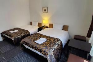 
a hotel room with two beds and two lamps at Tachikawa Regent Hotel in Tachikawa
