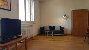 salon z telewizorem i kanapą w obiekcie Little Suite - Marceau w Lille