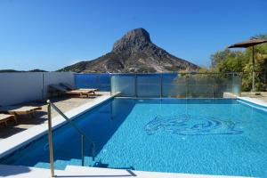 a swimming pool with a mountain in the background at MASSOURI BEACH HOTEL in Masouri