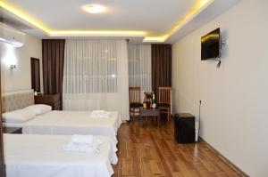 una camera d'albergo con due letti e una televisione di Hotel Grand Mark a Istanbul