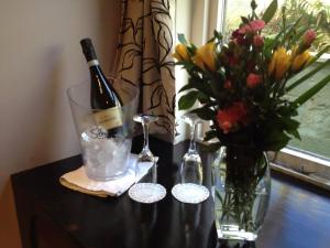 a bottle of wine and a vase of flowers on a table at Auld Mill House Hotel in Dunfermline
