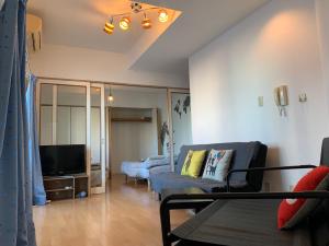 a living room with a couch and a tv at ETERNITY Tamatsukuri 401 in Osaka