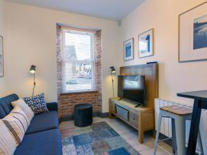 a living room with a blue couch and a television at Macs Townhouse Dungarvan in Dungarvan