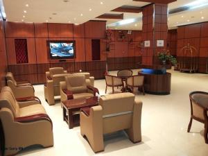 a waiting room with chairs and tables and a tv at Khayal Hotel Apartments in Riyadh