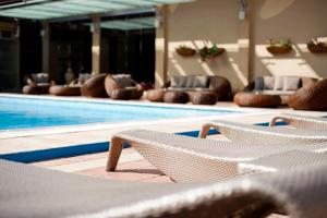 a pool with lounge chairs and a swimming pool at Congo Palace in Athens