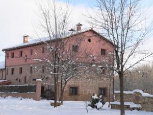 un gran edificio de ladrillo con árboles en la nieve en La Insula de Castilnuevo en Castilnuevo