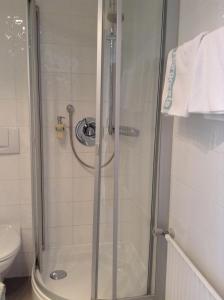 eine Dusche mit Glastür im Bad in der Unterkunft Gästehaus Margarete in Bad Wiessee