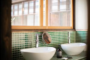 La salle de bains est pourvue de 2 lavabos blancs et d'une fenêtre. dans l'établissement Higurashi-sou, à Kyoto