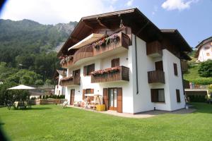 a white building with balconies and a yard at Villa Giardino - Flowers in Molveno