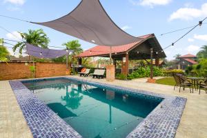 a swimming pool with a mosquito net over a house at Villa Kiambang in Seremban