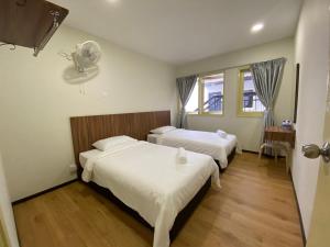 um quarto de hotel com duas camas e uma ventoinha em The Pines at Fraser's Hill, Malaysia em Bukit Fraser
