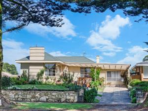 a house with a stone fence in front of it at Bloom on Sackville Opt1 in Port Fairy