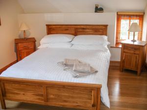 a large bed with a tray with two towels on it at The Hagguard in Kilgetty