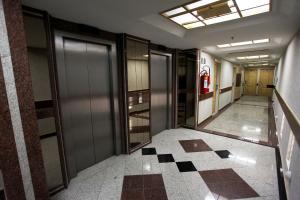 里約熱內盧的住宿－優雅普利亞酒店，空的走廊,有门,铺着瓷砖地板