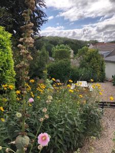 a garden with flowers and a bench at Séjour au vert in Vert