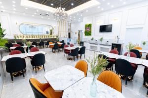 comedor con mesas y sillas y TV en Ashton Hotel en Ulsan