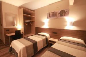 Pokój hotelowy z 2 łóżkami i biurkiem w obiekcie Hotel, H de l'Anton w mieście Batea