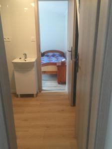 einen Flur mit einem Waschbecken und einem Bett in einem Zimmer in der Unterkunft Mobile House in Liptovský Trnovec