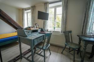 Habitación con escritorio, cama y ventanas. en Hotel Celler Auszeit, en Celle
