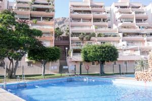 a swimming pool in front of a large apartment building at Seaport Aguadulce Beach in Aguadulce