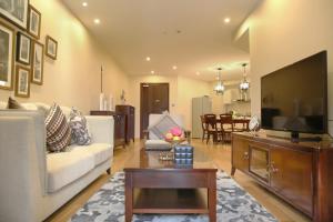 a living room with a couch and a flat screen tv at Green Court Residence Jinqiao Diamond Shanghai in Shanghai