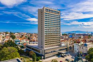 een hoog wit gebouw met een stad op de achtergrond bij Hotel Bulgaria in Boergas