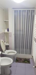e bagno con servizi igienici bianchi e doccia. di AMaTa House a Taranto