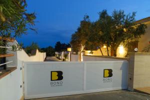 una cerca blanca con el logotipo de bong en ella en Bono Vacanze Villa San Marco Luxury Holidays Homes & Hotel, en Sciacca