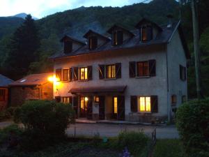 une grande maison éclairée la nuit dans l'établissement Auberge Les Myrtilles, à Couflens