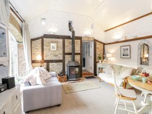 - un salon avec un canapé et une cheminée dans l'établissement The Old Byre, à Willsborough