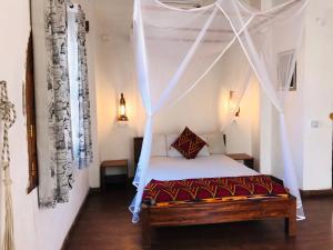 a bedroom with a bed with a mosquito net at Cafe Central in Ilha de Moçambique