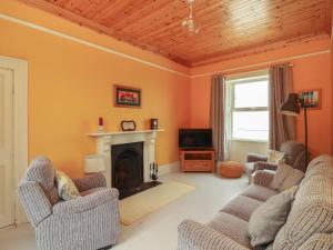 a living room with two chairs and a fireplace at Newtown East in Kilkee