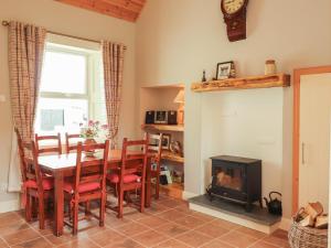 a dining room with a table and a fireplace at Newtown East in Kilkee