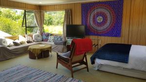 a bedroom with a bed and a tv and a couch at Champion Road Studio in Stoke