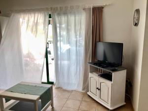 salon z telewizorem z płaskim ekranem na stojaku w obiekcie Casa Maiakai w mieście Playa Blanca
