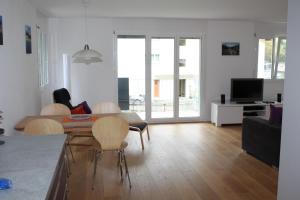 uma cozinha e sala de estar com mesa e cadeiras em Apartment Beeli em Splügen