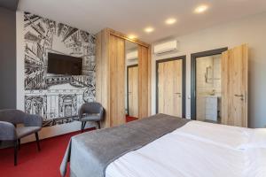 een slaapkamer met een bed en een tv aan de muur bij Hotel Kronverk in Sint-Petersburg