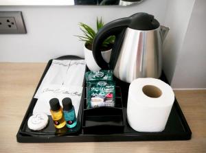 ein Tablett mit Toilettenpapier, eine Kaffeemaschine und eine Toilettenpapierrolle in der Unterkunft D5 Gold สาขา หนองกะขะ in Chon Buri
