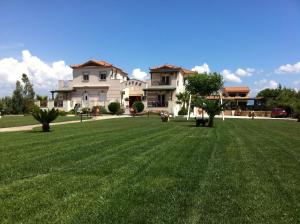 a large grassy yard in front of a large house at ilyda Residence apts in Skala Kallonis