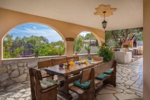 an outdoor dining room with a table and chairs at Villa Bravura Milna in Milna