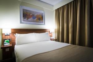 a hotel room with a bed and a painting on the wall at Holiday Inn Chester South, an IHG Hotel in Chester