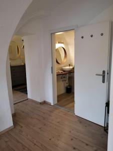 a hallway with a mirror and a sink in a bathroom at Zur alten Post Zittau in Zittau +26 photos