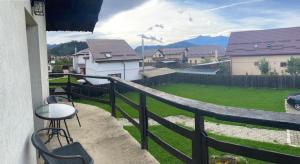 a balcony with a table and chairs and a view of a yard at Apartament Ella in Râşnov