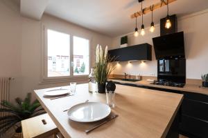 une cuisine avec une table en bois et des plaques de cuisson. dans l'établissement DORMIR A CLERMONT-FERRAND - Safari, à Clermont-Ferrand