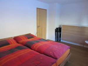 1 Schlafzimmer mit 2 Betten und bunten Decken in der Unterkunft Apartment Beeli in Splügen