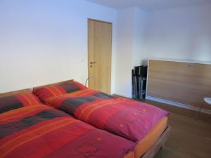 シュプリューゲンにあるApartment Beeliのベッドルーム(カラフルな毛布付きのベッド2台付)