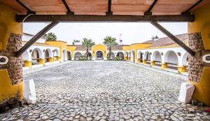 an empty courtyard of a building with yellow and white buildings at Herdade da Diabroria - Agroturismo in Beringel