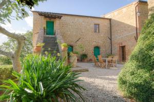 una vista exterior de un edificio con mesa y sillas en Holiday Home Arpicella, en Pienza