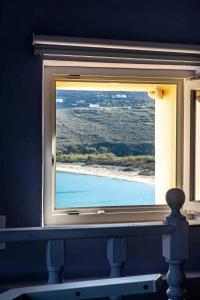 a window in a room with a view of a beach at Castel Abaso Boutique Apartments by Explore Andros in Andros