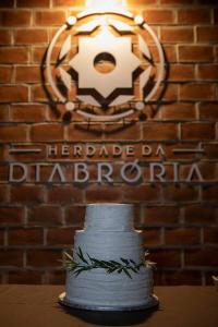 un gâteau blanc assis sur une table devant un mur de briques dans l'établissement Herdade da Diabroria - Agroturismo, à Beringel